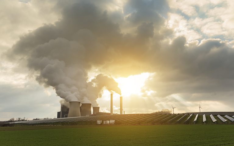 A Coal-fired power plant with solar enegerie and windmills and cloudy sky and sunlight. Taken outside with a 5D mark III.
